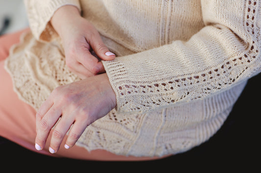 Jen gently touches the cuff of a long sleeved tee, knit with feminine lace touches