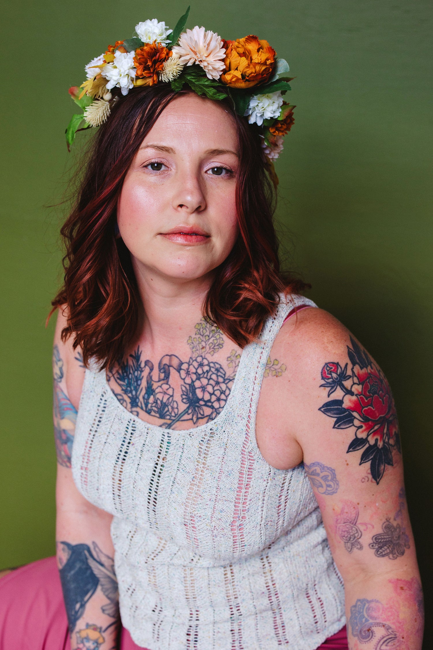 Bess wears a handknit tank and a flower crown. This knitting pattern features a tailored fit and bust darts.