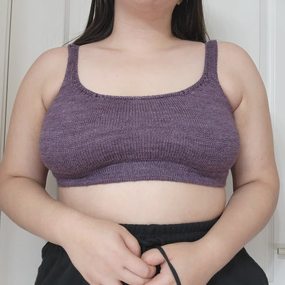 Jordynn, seen from the shoulders down, wears a deep purple bralette, knit to a tailored fit.