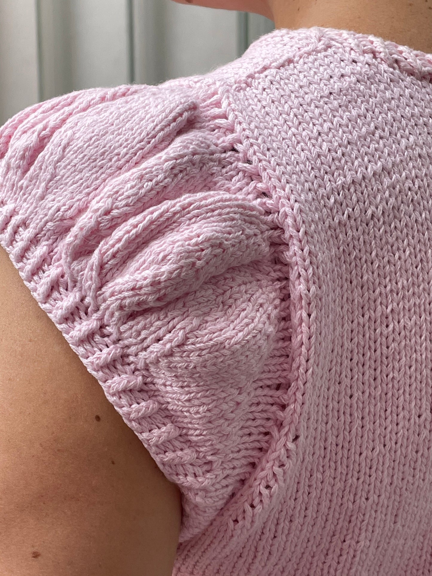 A close up of the ruffled sleeves on the Mae Summer Crop, showing the detail of the knit gathers that create the puffed shape.